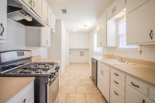 kitchen featuring sink, light tile patterned floors, stainless steel appliances, white cabinets, and decorative backsplash