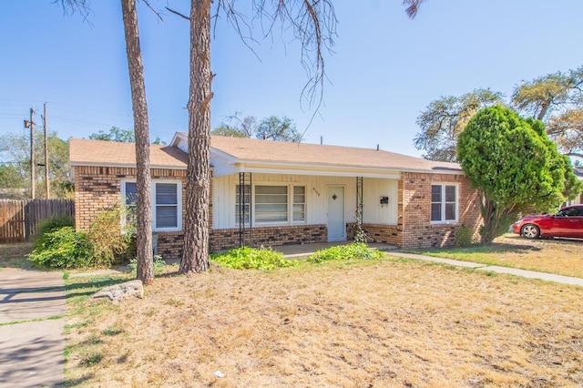 single story home with covered porch and a front lawn