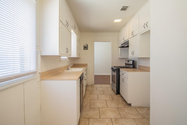 kitchen featuring white cabinetry, sink, decorative backsplash, light tile patterned floors, and stainless steel appliances