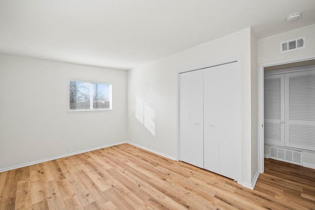 unfurnished bedroom with a closet and light hardwood / wood-style flooring