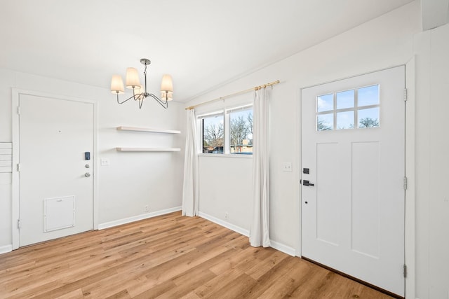 foyer entrance with an inviting chandelier and light hardwood / wood-style floors