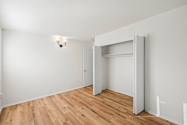 unfurnished bedroom with a closet and light wood-type flooring