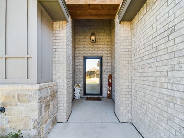 doorway to property featuring brick siding