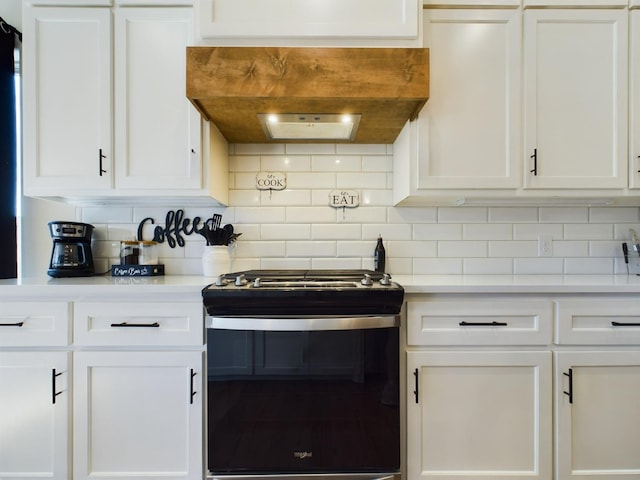 kitchen featuring range with gas cooktop, white cabinets, backsplash, and custom exhaust hood