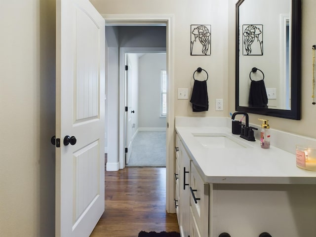 bathroom featuring vanity, baseboards, and wood finished floors