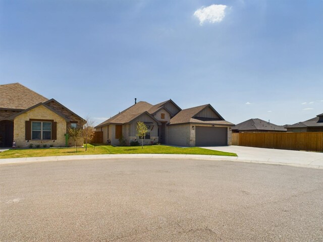 view of front of property featuring a garage, fence, a front lawn, and concrete driveway