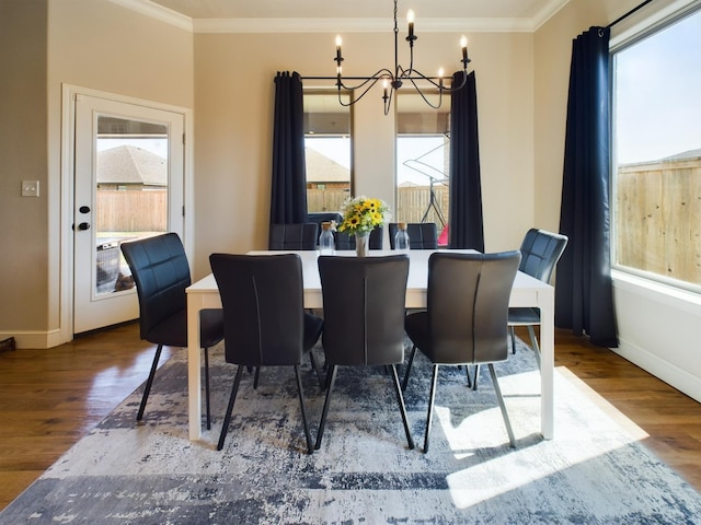 dining space with crown molding, wood finished floors, and a notable chandelier