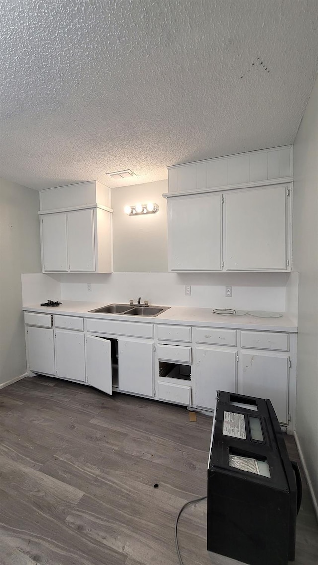 kitchen featuring sink, a textured ceiling, white cabinets, and dark hardwood / wood-style flooring