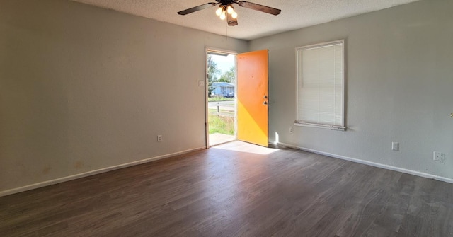 spare room featuring ceiling fan, dark wood-type flooring, and a textured ceiling