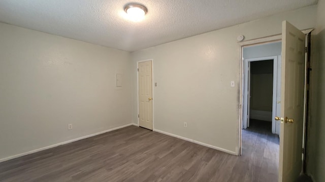 spare room with dark wood-type flooring and a textured ceiling