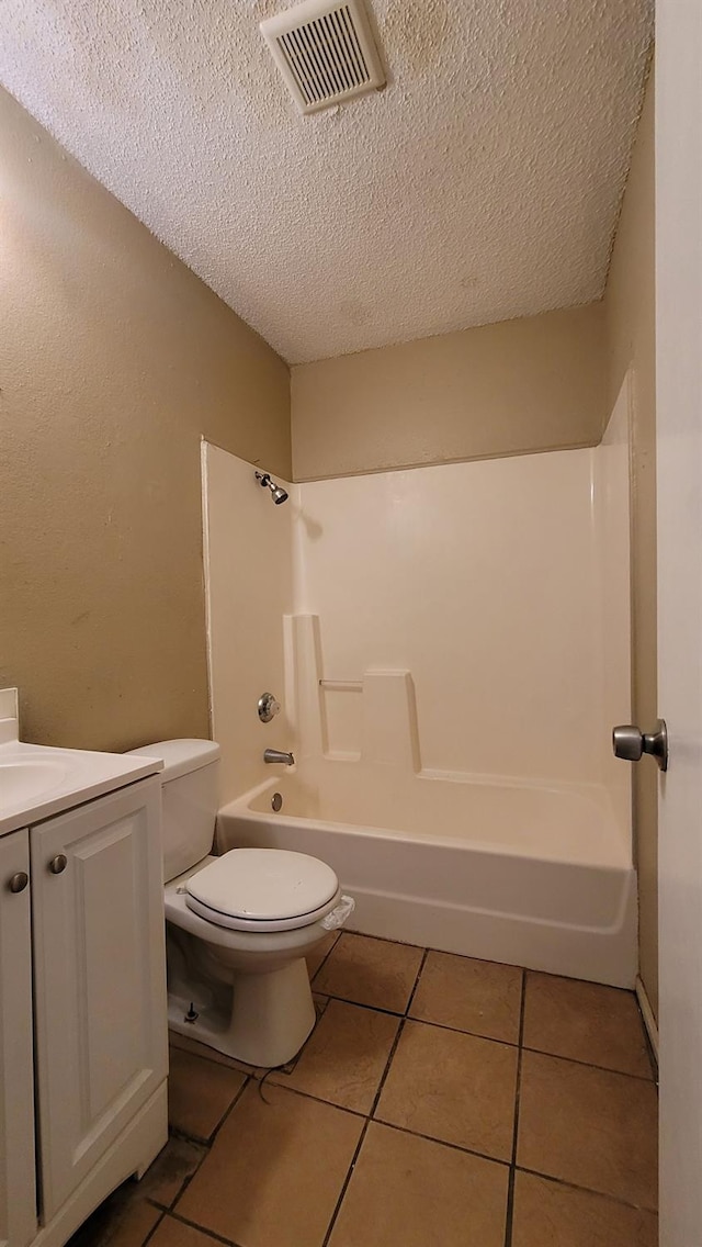 full bathroom with shower / bathing tub combination, vanity, toilet, tile patterned floors, and a textured ceiling