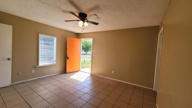 spare room featuring ceiling fan, tile patterned flooring, and a textured ceiling