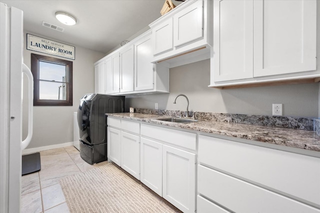 washroom with sink, washer / dryer, and cabinets