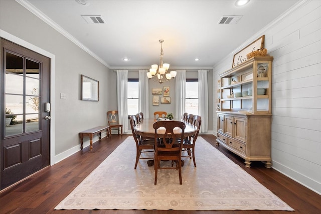 dining area featuring crown molding, dark hardwood / wood-style floors, and a chandelier