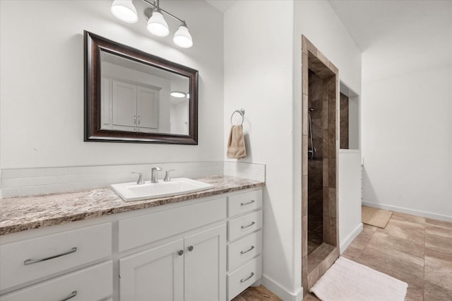 bathroom featuring a tile shower and vanity