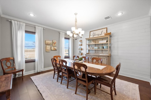 dining space with an inviting chandelier, ornamental molding, and dark hardwood / wood-style floors