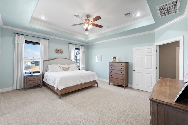 carpeted bedroom featuring ornamental molding, ceiling fan, and a tray ceiling