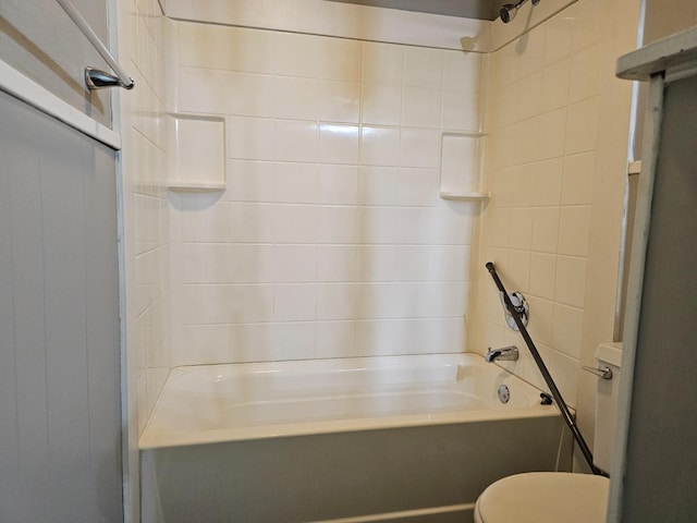 bathroom with tiled shower / bath combo and toilet