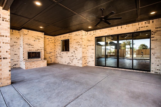 view of patio featuring an outdoor brick fireplace and ceiling fan