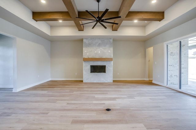 unfurnished living room featuring a high end fireplace, coffered ceiling, light hardwood / wood-style floors, and beam ceiling