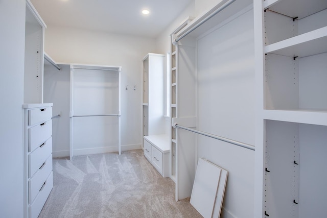 walk in closet featuring light colored carpet