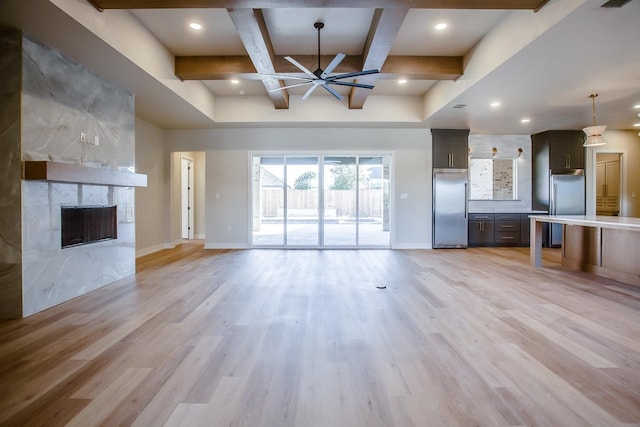 unfurnished living room with ceiling fan, coffered ceiling, a fireplace, and light hardwood / wood-style floors