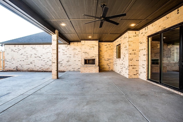 view of patio featuring an outdoor brick fireplace and ceiling fan