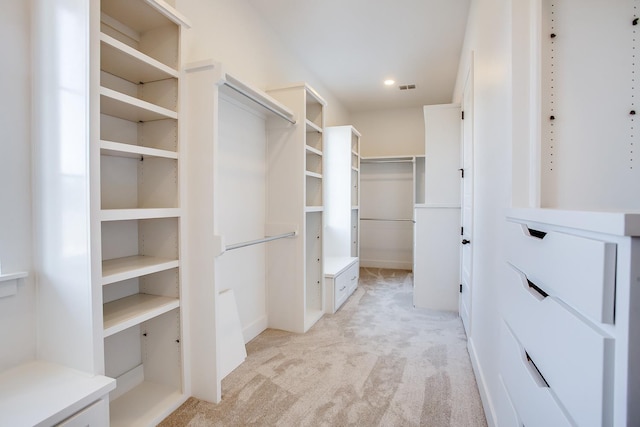 walk in closet featuring light colored carpet