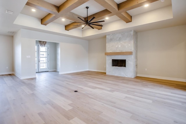 unfurnished living room featuring coffered ceiling, beam ceiling, light hardwood / wood-style flooring, ceiling fan, and a fireplace