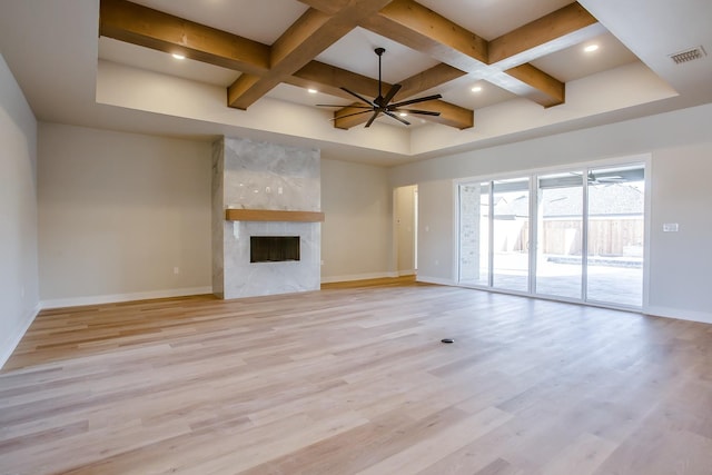 unfurnished living room featuring ceiling fan, coffered ceiling, a fireplace, and light wood-type flooring