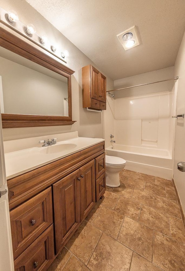 full bathroom with shower / washtub combination, vanity, a textured ceiling, and toilet