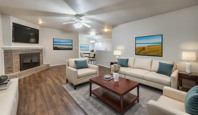 living room featuring ceiling fan, dark wood-type flooring, and a fireplace