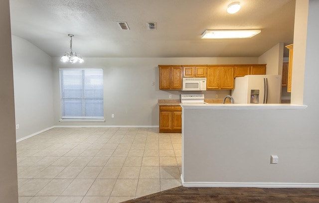 kitchen featuring decorative light fixtures, stainless steel fridge, range, light tile patterned floors, and an inviting chandelier