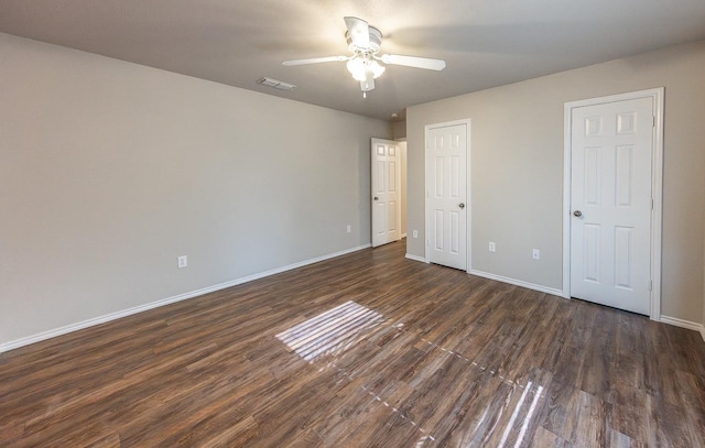 unfurnished bedroom featuring dark wood-type flooring and ceiling fan