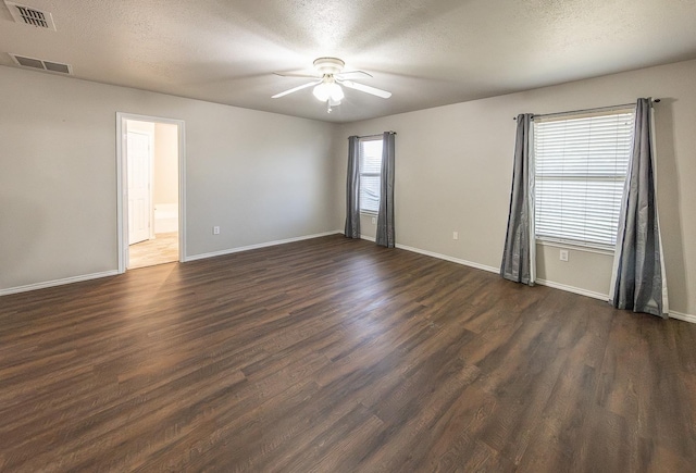 empty room with dark wood-type flooring and a textured ceiling