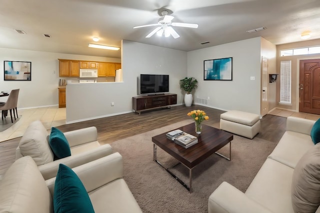 living room featuring wood-type flooring and ceiling fan