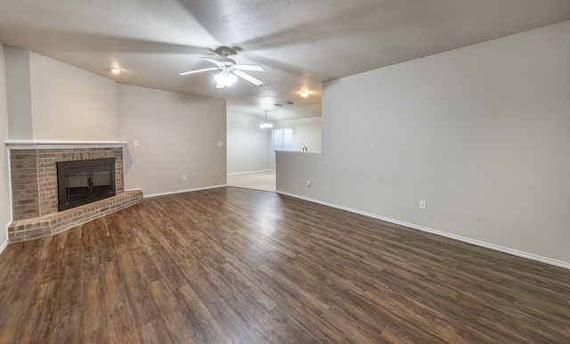 unfurnished living room featuring a textured ceiling, a fireplace, dark hardwood / wood-style floors, and ceiling fan