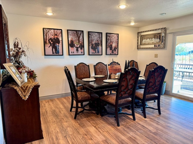 dining space featuring a textured ceiling and light hardwood / wood-style flooring