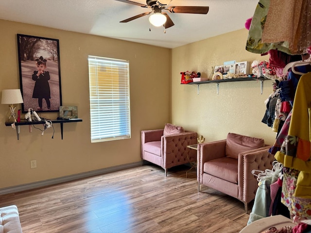 living area featuring ceiling fan and light hardwood / wood-style floors