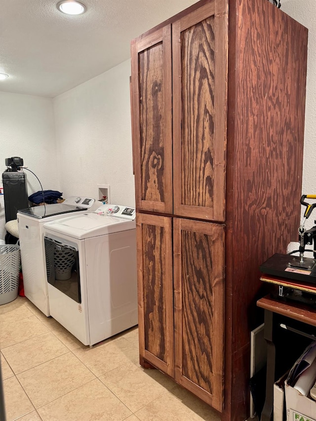 laundry area featuring cabinets, light tile patterned floors, and independent washer and dryer