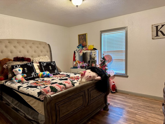 bedroom featuring wood-type flooring and a textured ceiling