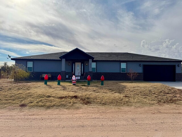 single story home with a garage and a front lawn