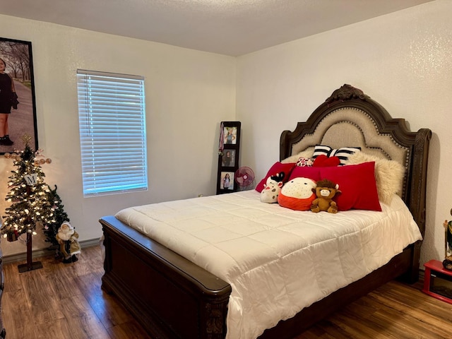 bedroom with dark hardwood / wood-style flooring