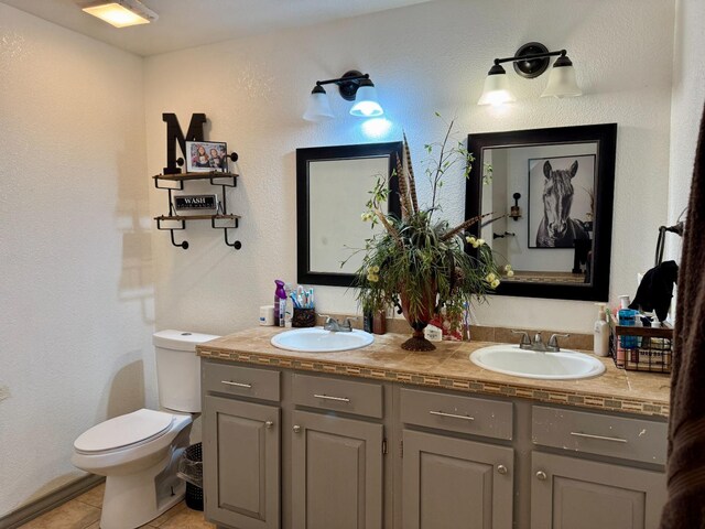 bathroom featuring vanity, tile patterned floors, and toilet