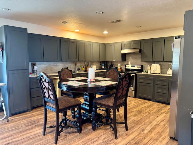 dining room featuring light hardwood / wood-style floors and a textured ceiling