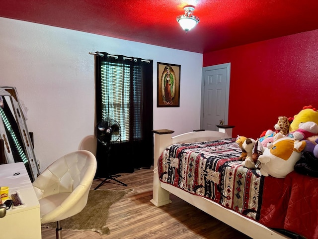 bedroom with hardwood / wood-style flooring and a textured ceiling