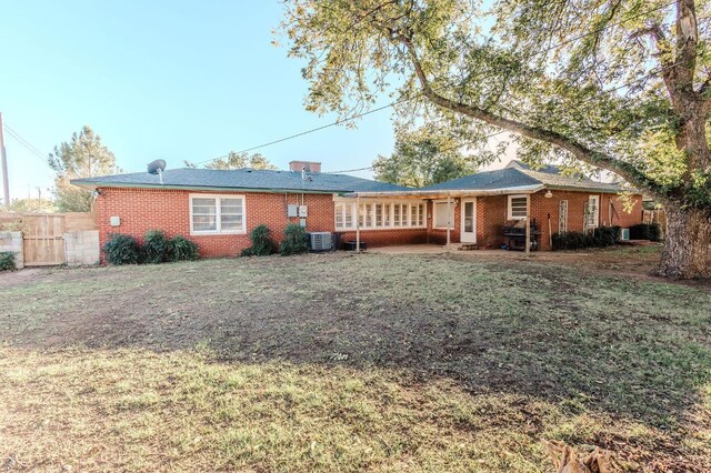 back of house featuring central AC and a lawn