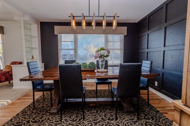 dining room with hardwood / wood-style flooring and built in shelves