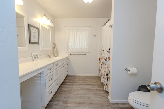 bathroom with hardwood / wood-style flooring, vanity, toilet, and a shower with curtain