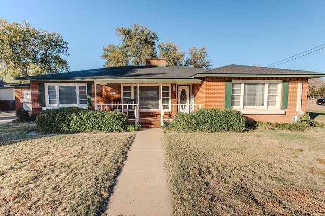 single story home with a front yard and covered porch